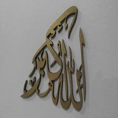 Gold Allah Hu Akbar Islamic calligraphy wall decor on grey wall, front view