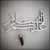White Assalamualaikum calligraphy key holder with car keys hanging on wall