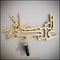 Gold Assalamualaikum Islamic calligraphy key holder with keys on grey wall