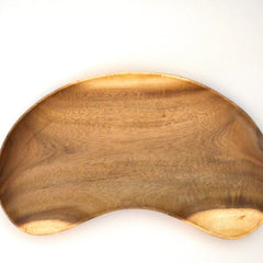 Close top view of empty cashew shaped wooden tray with wood grain