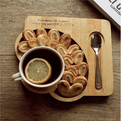 Wooden serving tray platter with lemon tea, cookies and spoon, top view