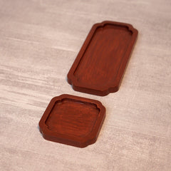 Empty reddish brown wooden tea trays, one long and one square