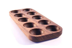 Mahogany wooden egg holder tray with ten round slots, angled view on white
