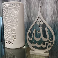 Teardrop shaped Mashaallah calligraphy table decor beside white vase