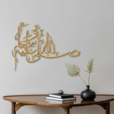 Gold Salawat laser cut calligraphy on grey wall above wooden console table