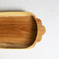 Close-up of scalloped handle end of rectangle wooden tray