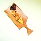 Top view of straight cut wooden serving tray with cheese and dried fruit