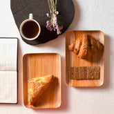 Rectangle wooden platter trays serving bread and croissant beside coffee