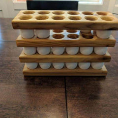 Stacked wooden egg holder trays filled with white eggs on kitchen counter