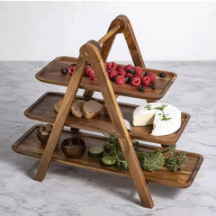 Three-tier wood serving tray rack holding berries, cheese and snacks on marble