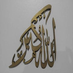 Gold Allah Hu Akbar Arabic calligraphy wall art on grey wall, side angle