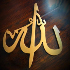 Gold Allah Islamic calligraphy decor piece displayed on dark wooden surface