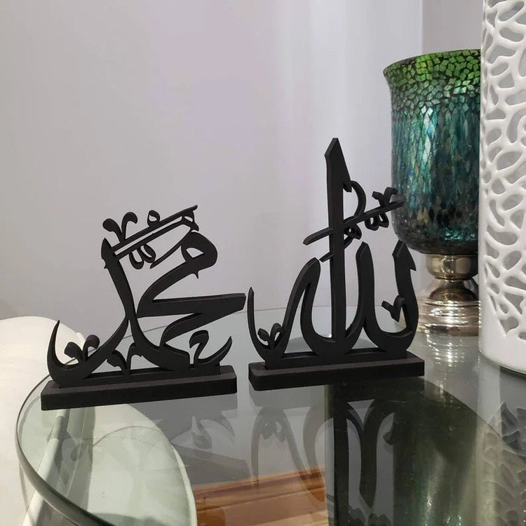 Close-up of black Allah Muhammad calligraphy stands on glass table