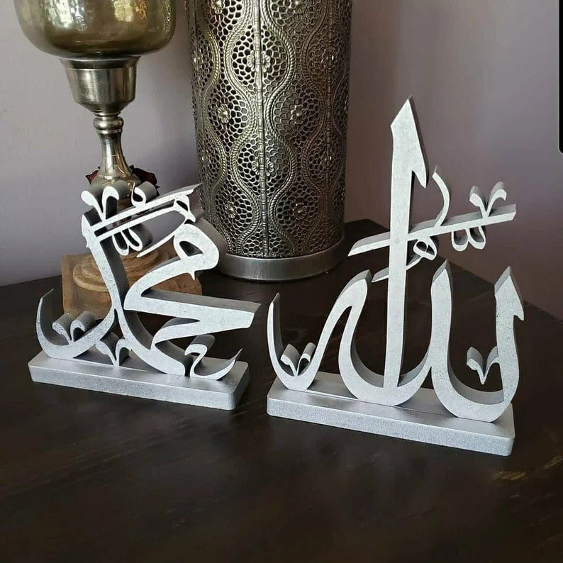 Silver Allah Muhammad calligraphy table sculptures beside metallic vase