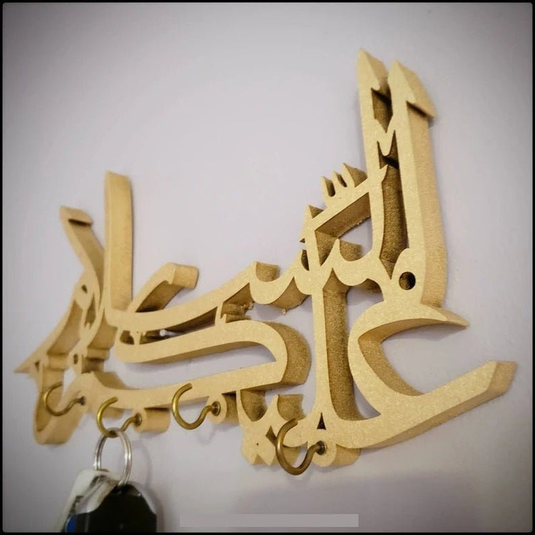 Angled side view of gold Assalamualaikum calligraphy key holder with keys