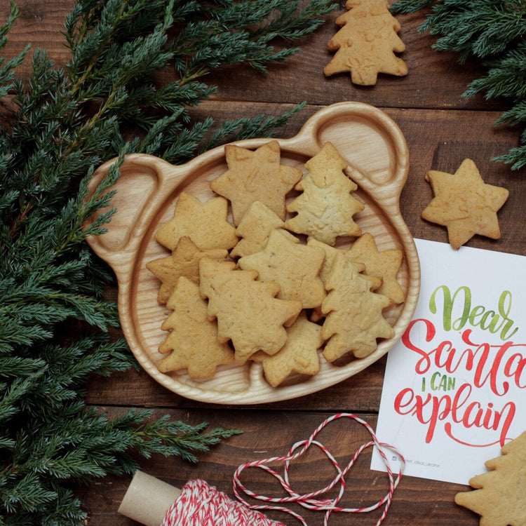 Bear wooden serving platter full of cookies with pine branches, festive setting