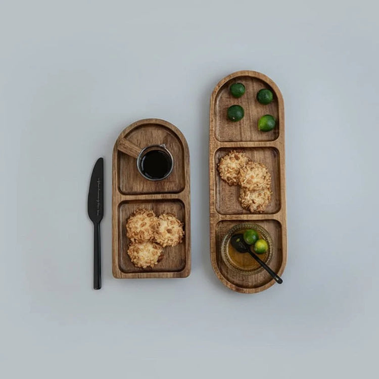 Two wave oval wooden trays with cookies and nuts on grey background, top view