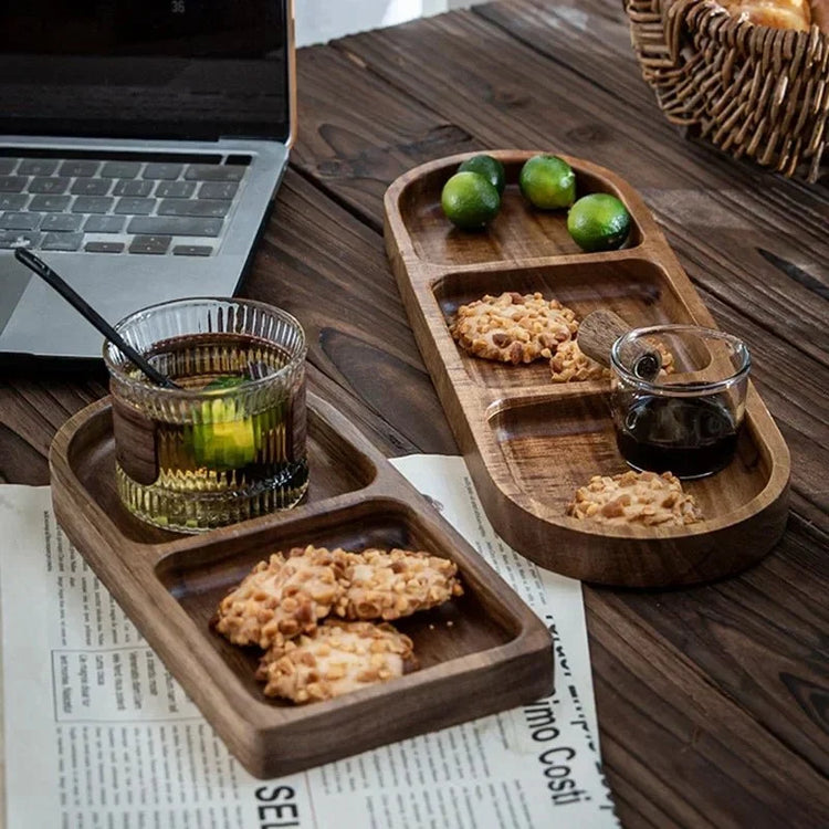 Oval wooden trays with cookies, sauce and drink beside laptop on table