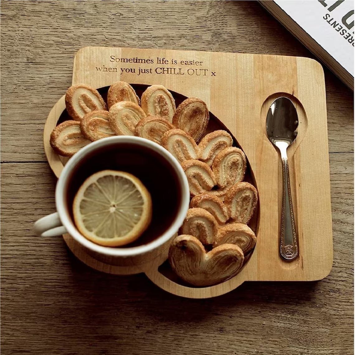 Wooden serving tray platter with lemon tea, cookies and spoon, top view