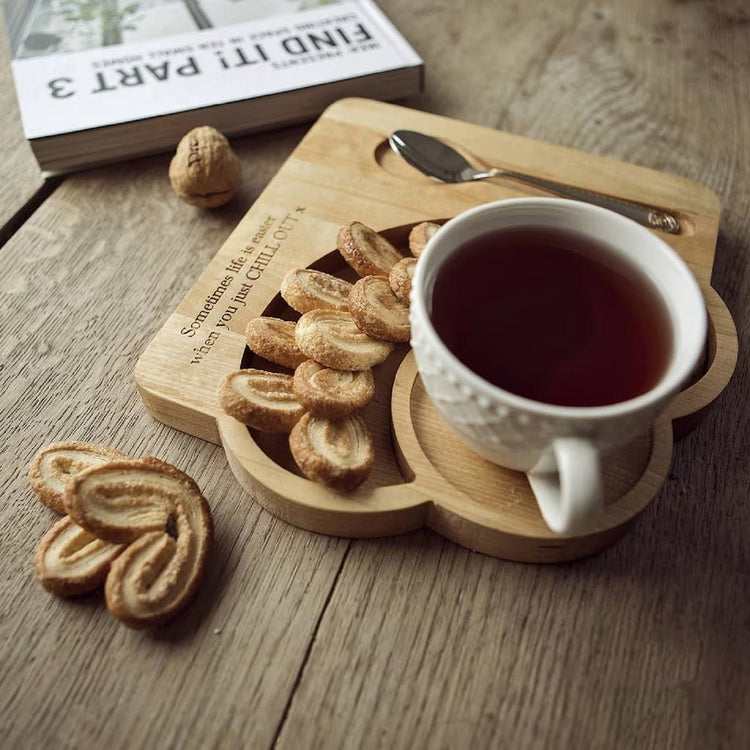 Solid wood serving platter with cup of tea and palmier biscuits on rustic table