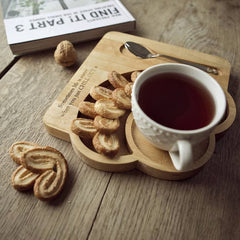 Solid wood serving platter with cup of tea and palmier biscuits on rustic table