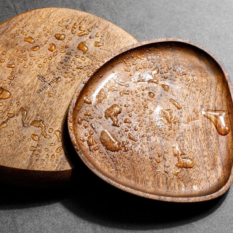 Water droplets on dark wooden serving trays, close-up view