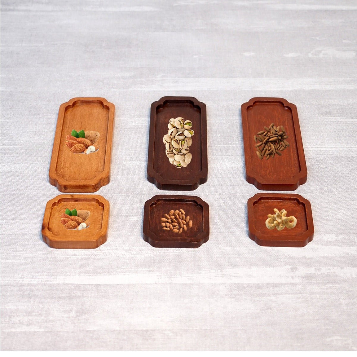 Six wooden tea trays in light and dark finishes holding snacks