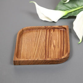 Single square wooden serving platter tray with grooved lines beside white lily