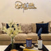 Gold Hasbunallahu laser cut calligraphy above beige sofa in living room