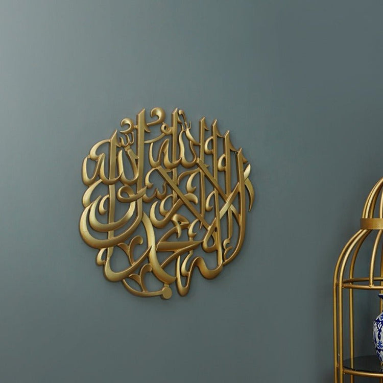 Round gold Kalma Shareef calligraphy on dark wall with gold cage at side