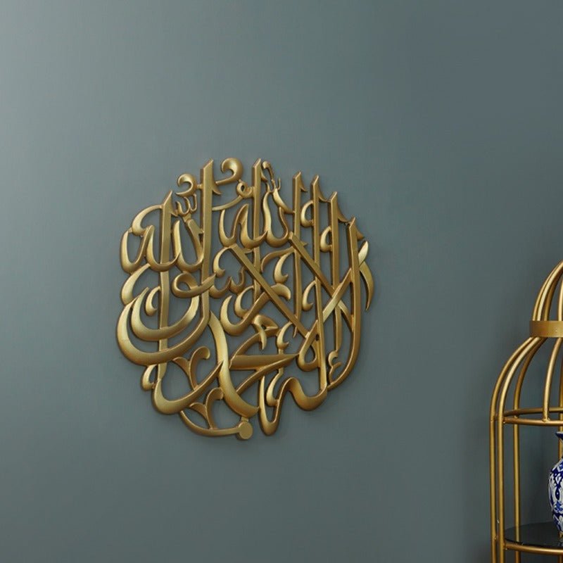 Round gold Kalma Shareef calligraphy on dark wall with gold cage at side