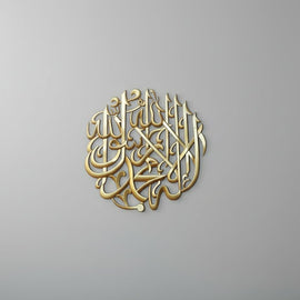 Round gold Kalma Shareef calligraphy wall art on plain grey wall
