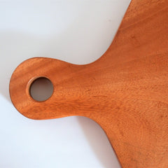 Close-up of handle and hanging hole of wooden cheese platter