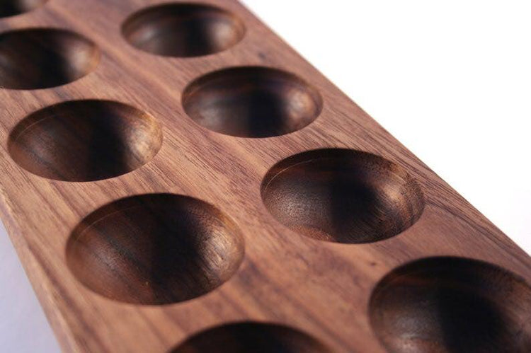 Close-up of carved round slots and wood grain of mahogany egg holder tray