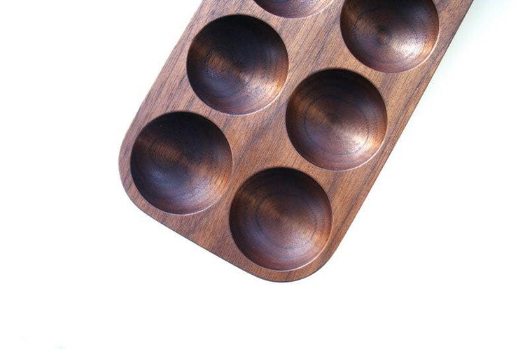 Six slot mahogany egg holder tray, angled top view on white background