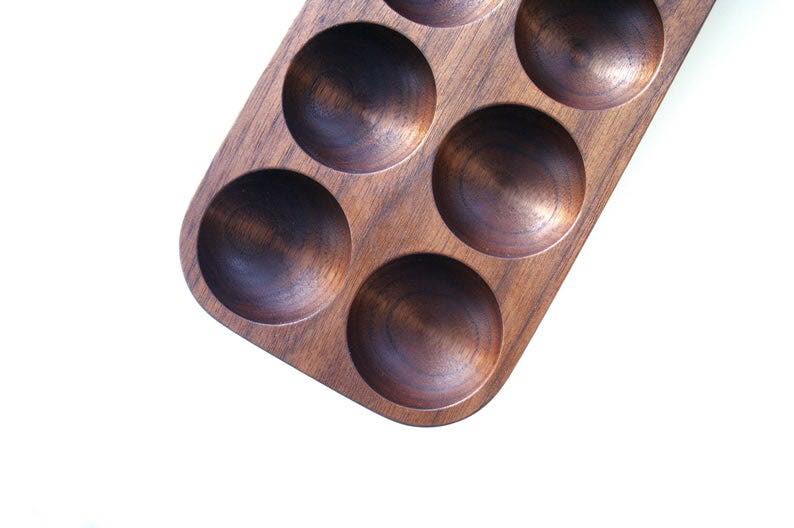Six slot mahogany egg holder tray, angled top view on white background