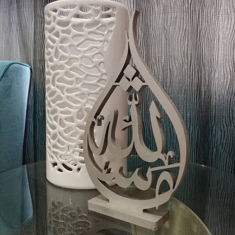 Close-up of beige Mashaallah calligraphy table sculpture on glass table