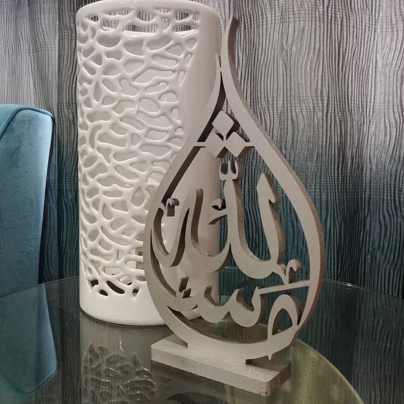 Close-up of beige Mashaallah calligraphy table sculpture on glass table