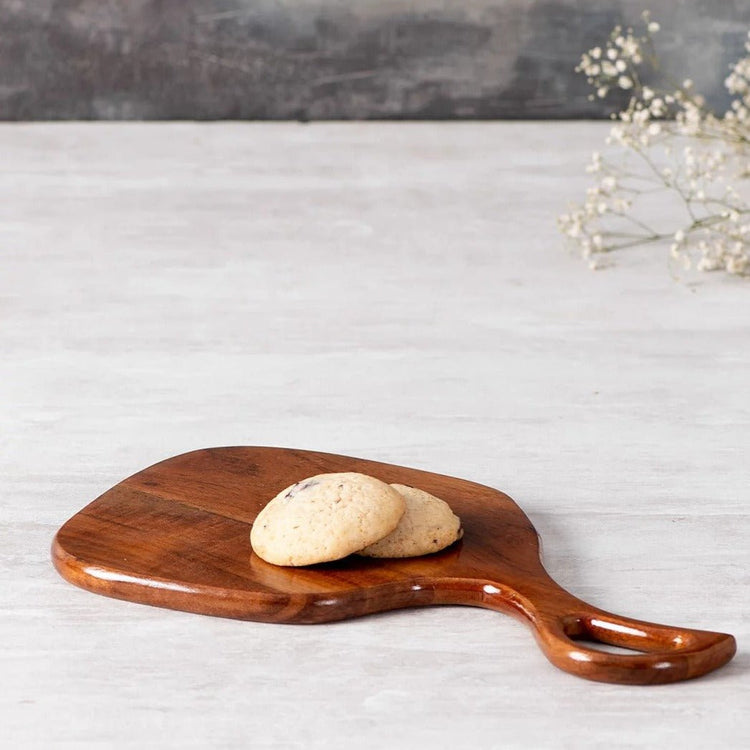 Open handle wooden snack serving tray with cookies on white marble table