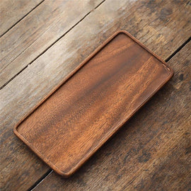 Single rectangular wooden serving tray on rustic wood table, angled top view