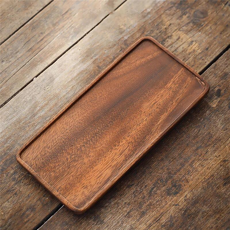 Single rectangular wooden serving tray on rustic wood table, angled top view