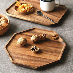 Octagon wooden platters holding walnuts and snacks beside coffee cup