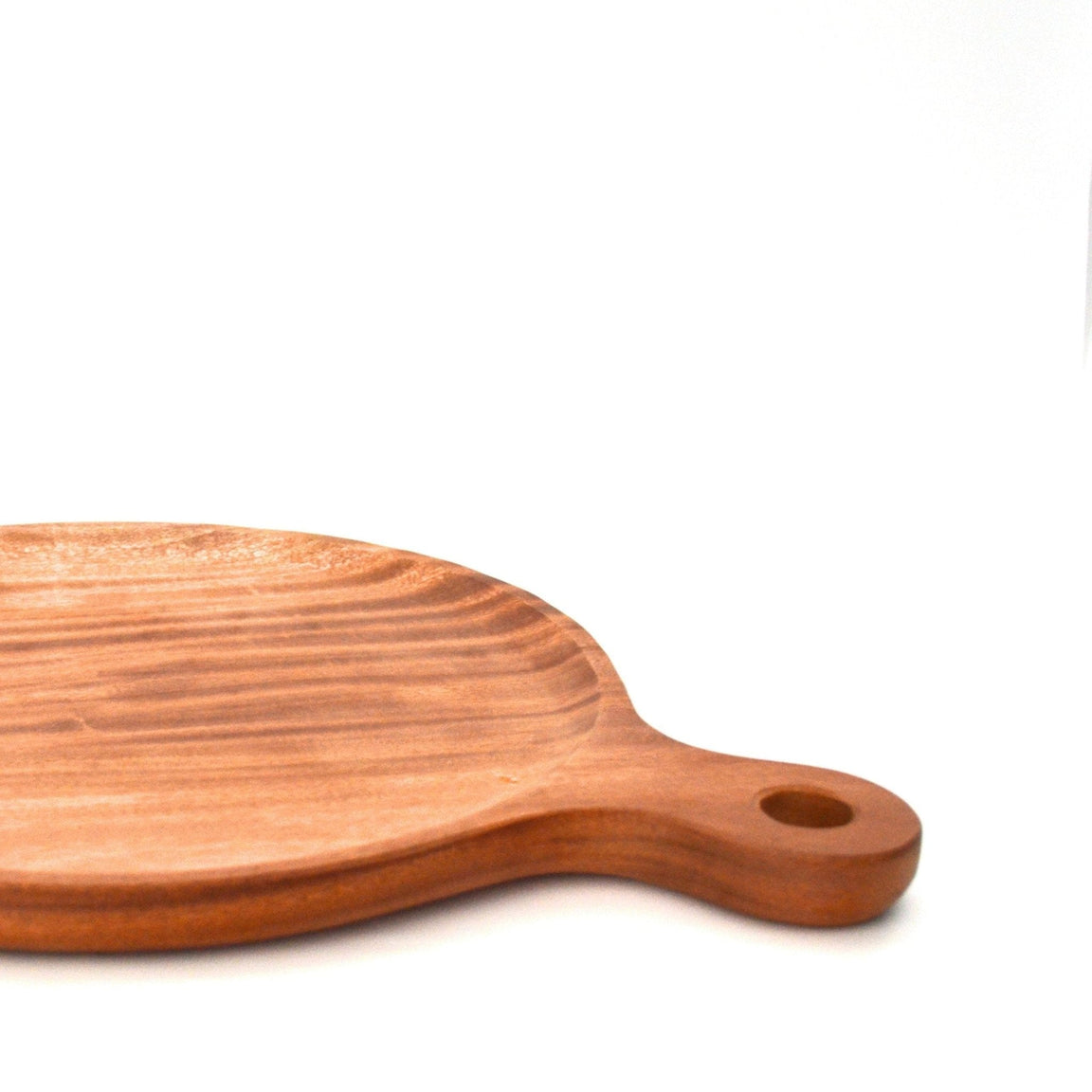Side view of round wooden pizza platter showing handle with hanging hole