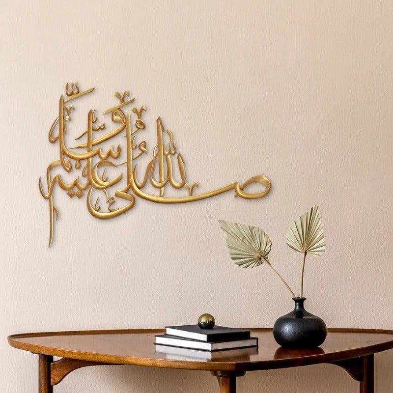 Gold Salawat laser cut calligraphy on warm beige wall above wooden table