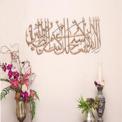Gold Tasbih-e-Yunus calligraphy wall art on beige wall with flower vases