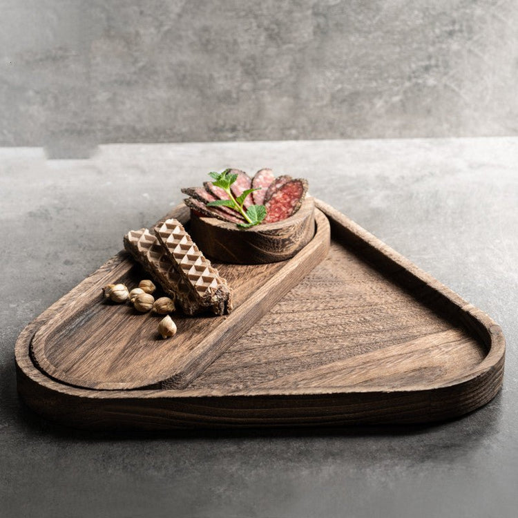 Dark triangle wooden platter tray with chocolates and succulent on concrete surface