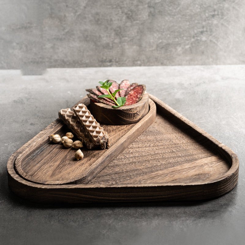Dark triangle wooden platter tray with chocolates and succulent on concrete surface