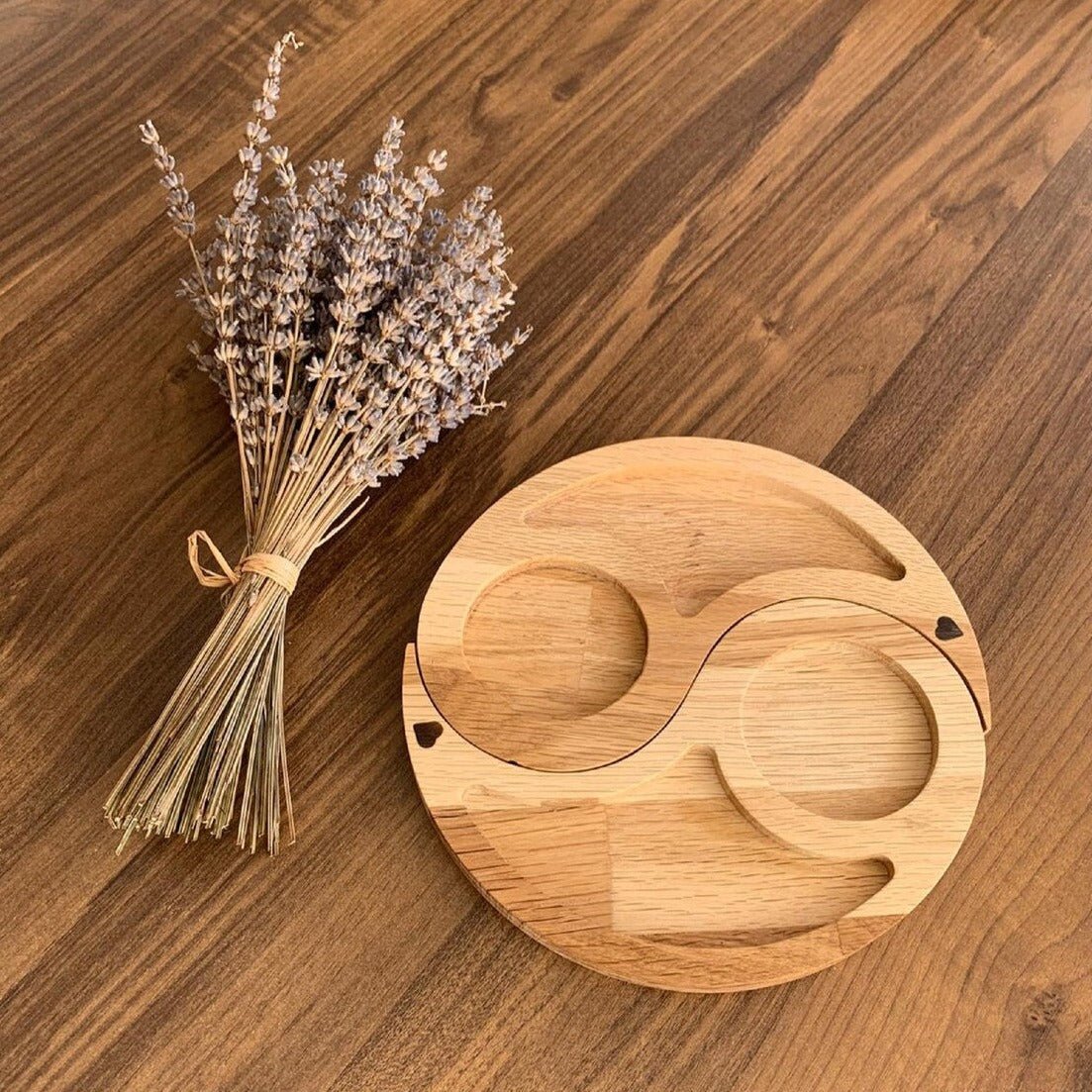 Yin yang wooden tray with one half removed next to lavender bunch