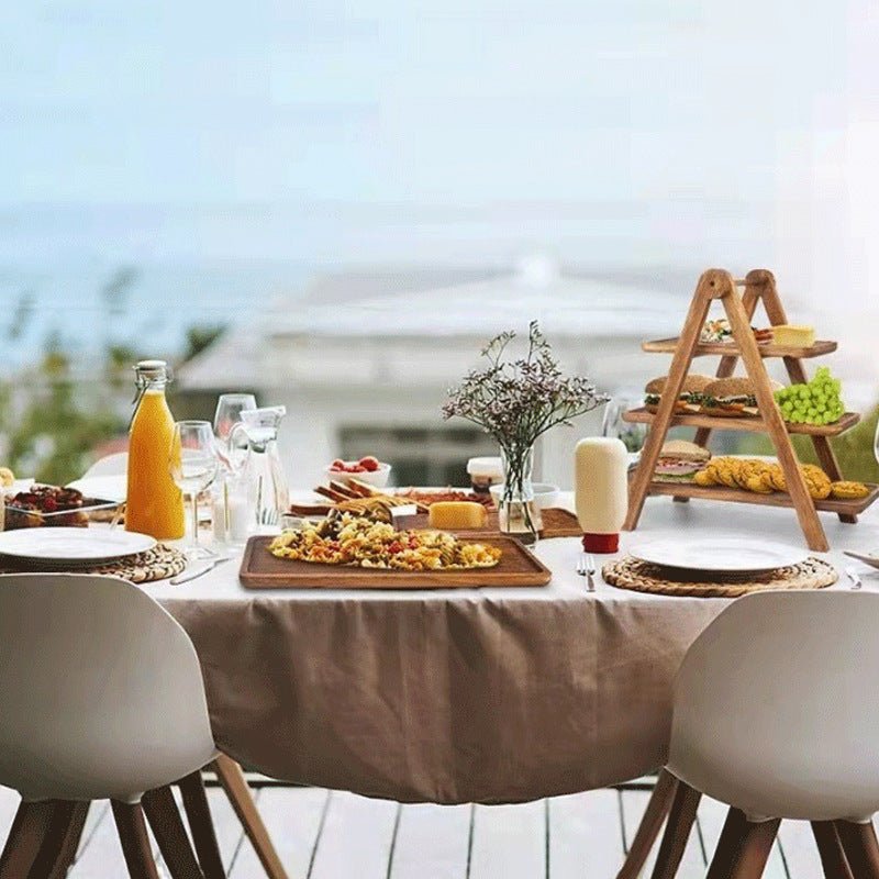 Tiered wooden serving tray rack on outdoor dining table set for a meal